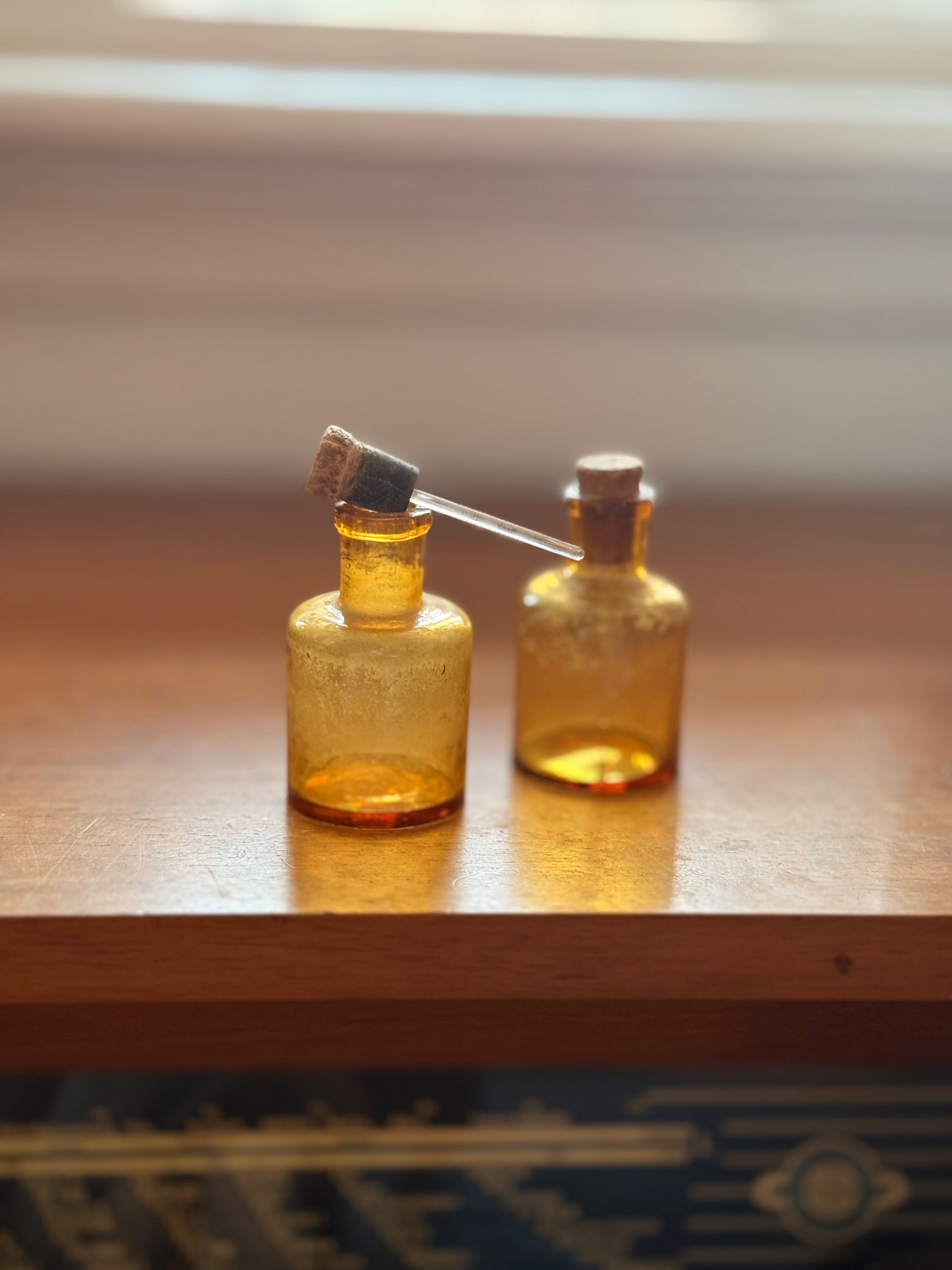 Pair of amber glass dropper jars, 1940s–60s